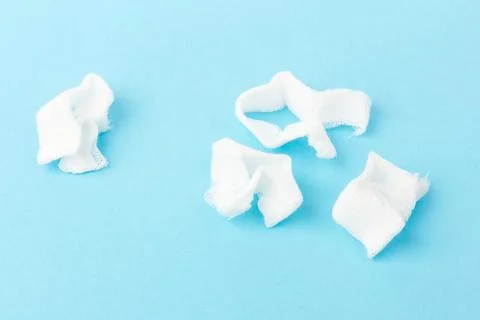 White gauze pads on  blue background. Materials for dental surgery. Close up Stock Photos