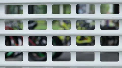 White geometric metal security shutter with a blurred, colorful background of 動画素材 330345908