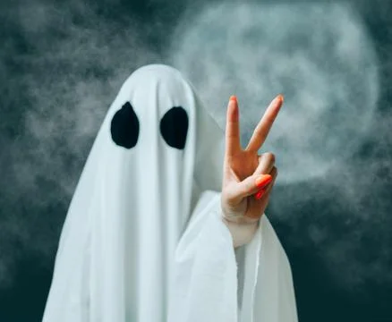 White ghost showing peace gesture in Halloween full moon night. Foto stock