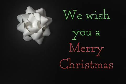 White gift bow on dark background with festive text wishing Merry Christmas, Stock Photos