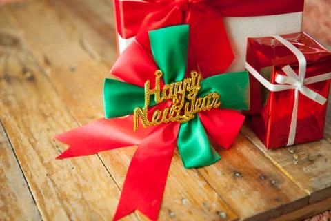 White gift box and red ribbon  on wood background with space.. Stock Photos