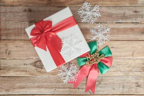 White gift box and red ribbon  on wood background with space.. Stock Photos