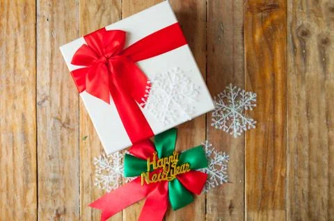 White gift box and red ribbon  on wood background with space.. Foto stock