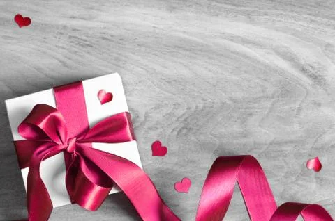White gift box and red ribbon with tag on wood background. Vintage gift box o Stock Photos