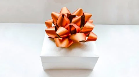 White gift box with a gold bow on a white background. Holiday concept Stock Photos