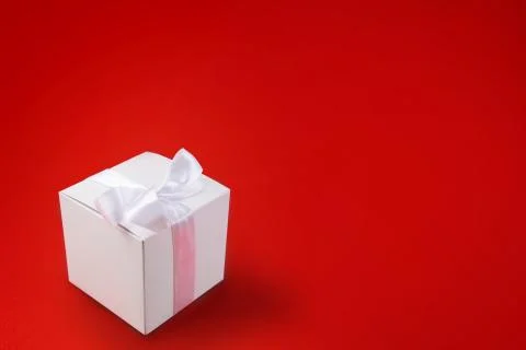 White Gift box on a red background. Space for text. Stock Photos