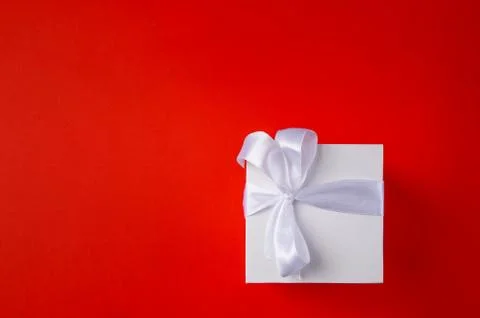 White Gift box on a red background. Space for text. Stock Photos