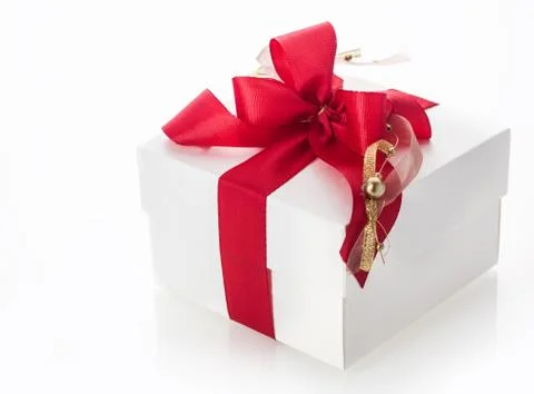 White gift box with a red bow and gold tassle Stock Photos