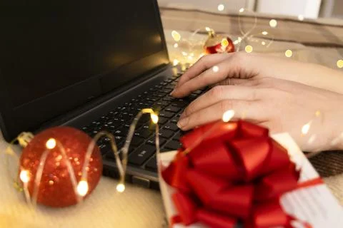 White gift box with red bow and laptop with christmas light Stock Photos
