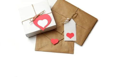 White gift box with red label in a heart form, gift wrapped in craft paper 스톡 사진