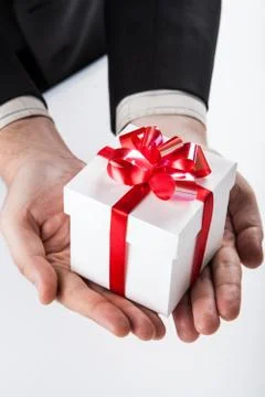 White gift box with red ribbon in hand Stock Photos