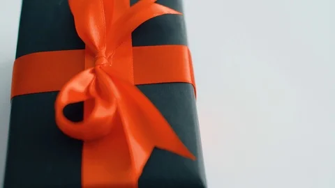 White gift box with red silk ribbon rotating.  Gift box for Christmas, black fri Stock Footage 115574698