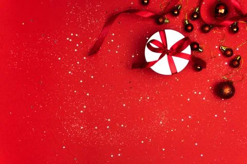White gift box in a round shape with a red ribbon on a red background Foto stock
