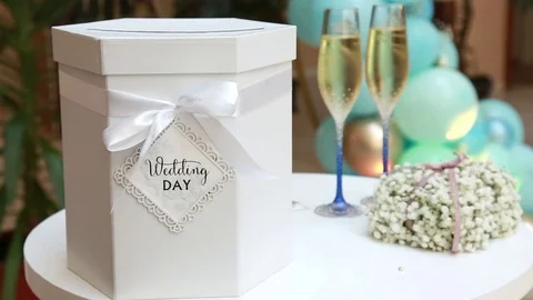 White Gift box, two wine glasses, flower bouquet on a table on wedding ceremony. Stock Footage 112048986
