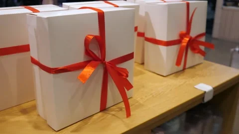 White gift boxes with red bow standing in a row. Gift packaging. 스톡 동영상 299735422