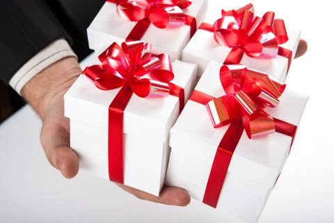 White gift boxes with red ribbon in hand Stock Photos