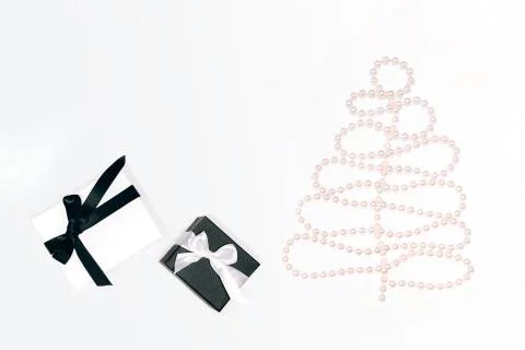 White gift or present box with black ribbon and beads in Christmas tree shape on Stock Photos