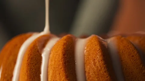White Glaze Being Poured Over Golden-brown Bundt Cake - Easter Food. closeup Stock-Footage 331093949