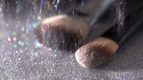 White glitter falling on makeup brushes on the black background, abstract slow Video stock 75967073