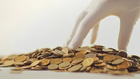 White-gloved hands scooping up a pile of gold coins. They sort out and scatter Stock Footage 122667090