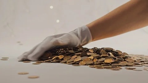 White-gloved hands scooping up a pile of gold coins. They sort out and scatter Stock Footage 122670110