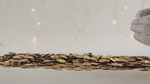 White-gloved hands scooping up a pile of gold coins. They sort out and scatter Stock Footage 122683350
