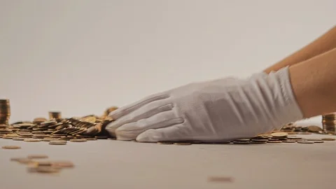 White-gloved hands scooping up a pile of gold coins. They sort out and scatter Stock Footage 122702232