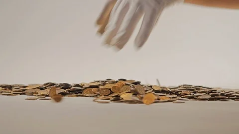 White-gloved hands scooping up a pile of gold coins. They sort out and scatter Stock-Footage 122704983