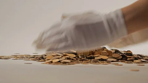 White-gloved hands scooping up a pile of gold coins. They sort out and scatter Stock Footage 122705458