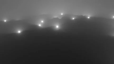 White glowing spheres fall over the hills in the fog. Stock Footage 138620553
