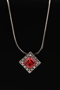 A white gold necklace with a ruby gemstone pendant Stock Photos