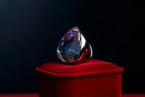 White gold ring with a large stone on a red velvet box. Stock Photos