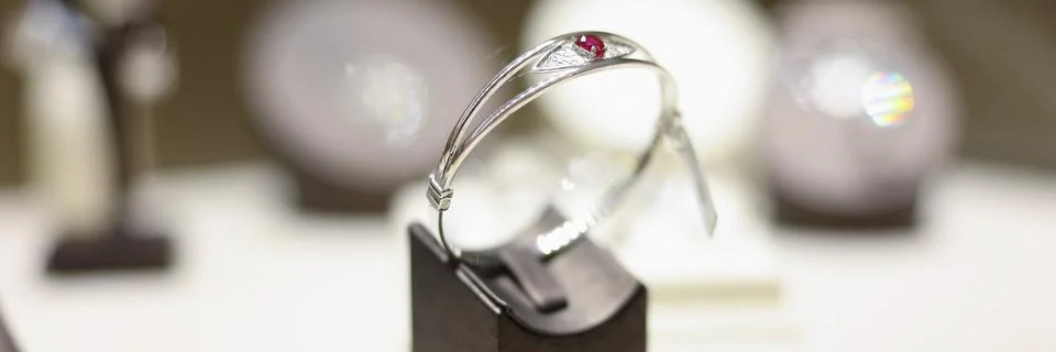 White gold ring with ruby on shop window closeup 스톡 사진