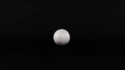 White golf ball dropping and bouncing on black surface in slow motion studi.. Stock Footage 333756639