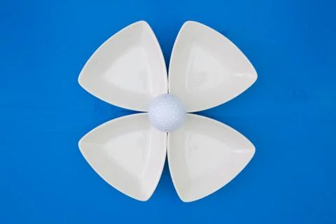 White golf ball on the triangular ceramic bowls 库存照片