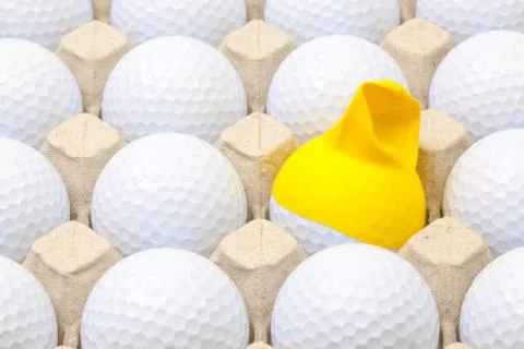 White golf balls in the box for eggs. Golf ball with funny cap. 스톡 사진