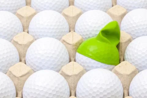 White golf balls in the box for eggs. Golf ball with funny cap. 스톡 사진