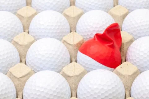 White golf balls in the box for eggs. Golf ball with funny cap. 스톡 사진