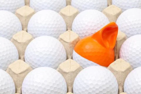 White golf balls in the box for eggs. Golf ball with funny cap. 스톡 사진