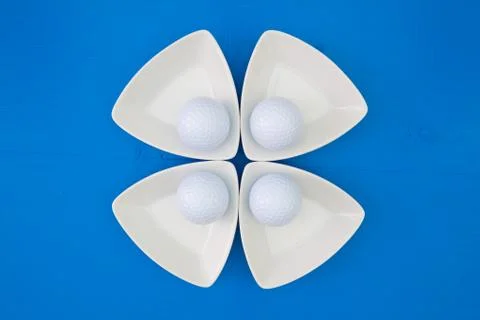 White golf balls on the triangular ceramic bowls 스톡 사진