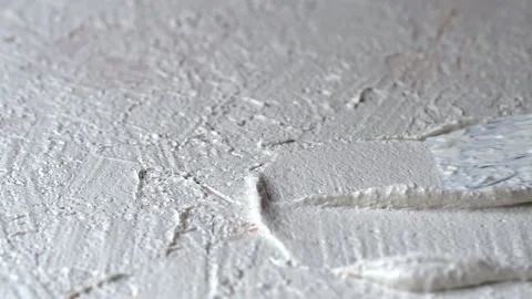 White granular plaster is applied with a spatula on a horizontal surface Stock Footage 142000256