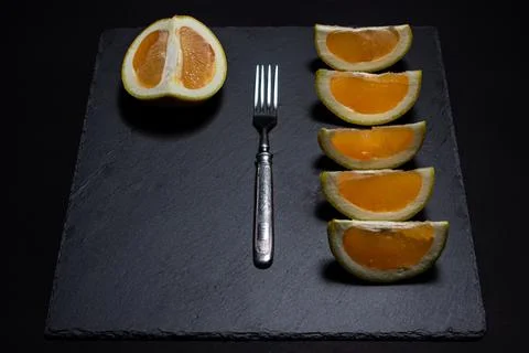 White grapefruit on a black background. Grapefruit slices on a black dish. Stock Photos