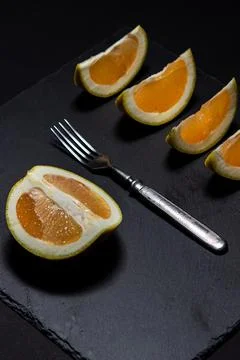 White grapefruit on a black background. Grapefruit slices on a black dish. Stock Photos