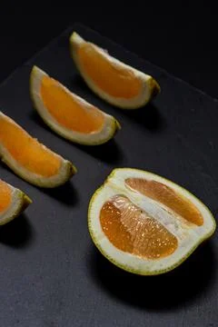 White grapefruit on a black background. Grapefruit slices on a black dish Stock Photos