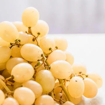 White grapes in a basket on a table Stock Photos