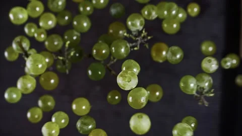White grapes fly up and hover in the air on a black background in slow motion Stock Footage 268744604