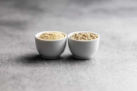 White ground pepper and whole peppercorn spice. Stock Photos
