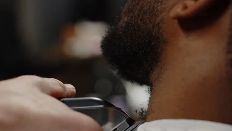 White guy shaving his beard with a trimmer to an African American guy - close-up Stock Footage 171219013