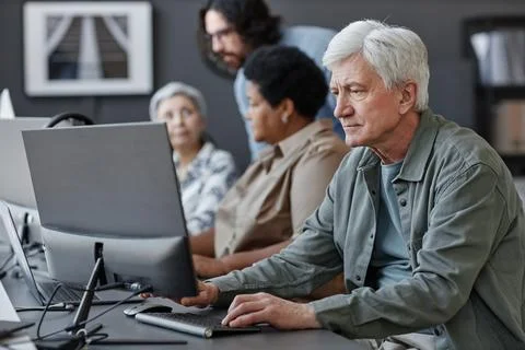 White haired senior man using computer in tech school for elderly people 写真素材