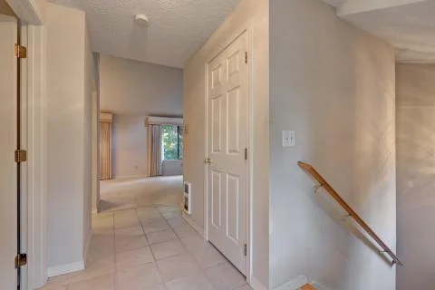 White hallway interior with tile floor and staircase to the basement. Northwe Stock Photos